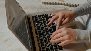 person with gray long sleeves typing an email