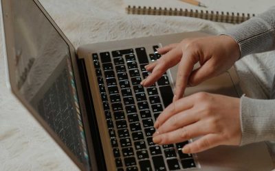 person with gray long sleeves typing an email